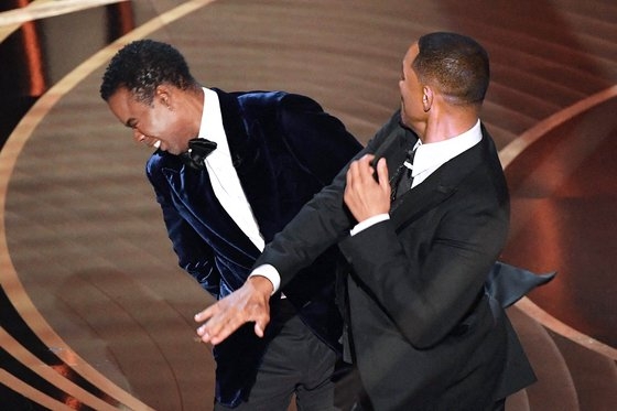 윌 스미스(오른쪽)가 지난 27일(현지시간) 아카데미 시상식 무대에 뛰어들어 시상자로 나선 배우 크리스 록의 빰을 때리고 있다. AFP=연합뉴스