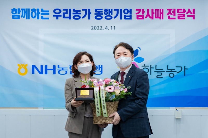 11일 NH농협은행 권준학 은행장(오른쪽)이 하늘농가(주) 고화순 대표(왼쪽)와 '함께하는 우리농가 동행기업' 선정을 축하하는 감사패와 꽃다발을 전달하며 기념촬영을 했다.