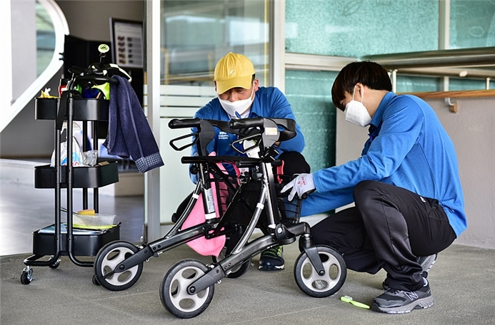 경기도재활공학서비스연구지원센터 발달장애인 보조기기 관리사가 이용자 휠체어를 세척·소독하고 있다.