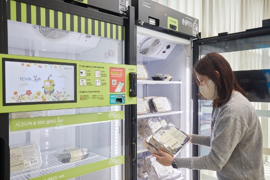 부산 에코델타시티 스마트빌리지 입주민이 웰니스센터 내 설치된 풀무원 O2O 무인플랫폼 ‘출출박스’에서 자신의 맞춤식사 ‘디자인밀’을 직접 픽업하고 있다.