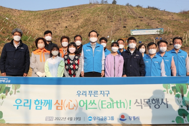 우리금융은 19일 산불피해로 복구가 진행중인 강릉시 옥계면 일대에서 소나무 묘목을 심는 식목행사를 진행했다. 손태승(오른쪽에서 여섯번째) 우리금융지주 회장, 이원덕(오른쪽에서 세번째) 우리은행장, 정일섭(오른쪽에서 네번째) 강릉시장 권한대행이 지역주민들, 우리금융 임직원들과 함께 기념촬영을 하고 있다.