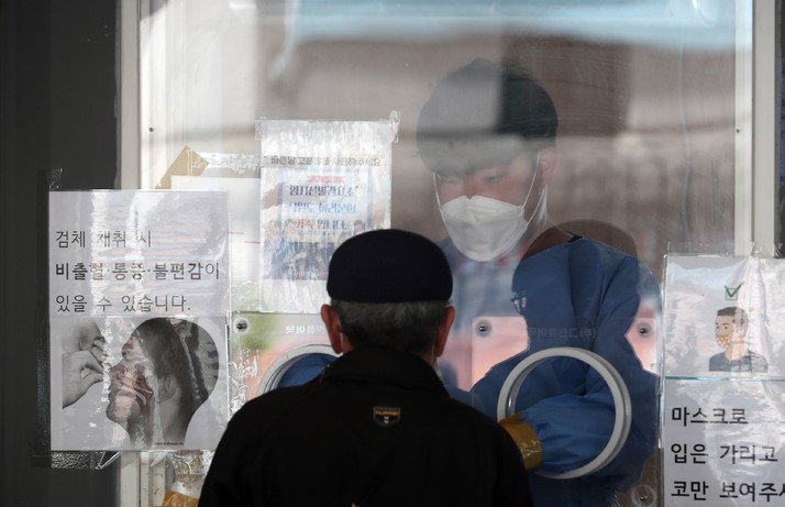 0시 기준 코로나19 신규 확진자수가 7만 6787명을 기록한 27일 서울역 임시선별검사소를 찾은 시민이 PCR검사를 하고 있다.