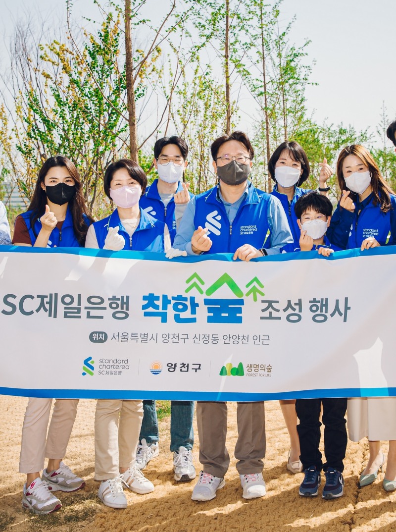 장호준(왼쪽 네 번째) SC제일은행 소매금융그룹장(부행장)과 임직원들이 지난 27일 서울 양천구 안양천 둔치에서 열린 ‘SC제일은행 착한 숲’ 조성 행사에서 기념촬영을 하고 있다.