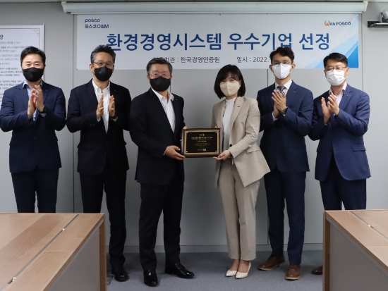 포스코O&M이 한국경영인증원으로부터 환경경영시스템 인증패를 받았다. (왼쪽부터 포스코O&M 이노수 행정지원섹션 리더, 김유석 경영지원실장, 김정수 대표, 한국경영인증원 황은주 대표, 조헌제 책임연구원, 포스코O&M 이평수 행정구매그룹장 순 )