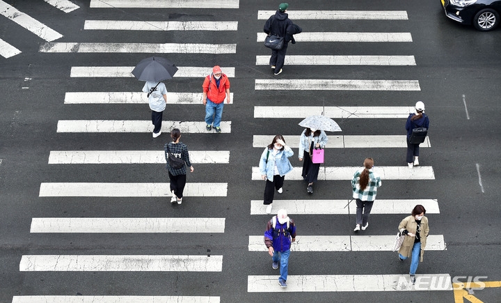 비가 내린 21일 오후 대구 동구 신천동 동대구역 복합환승센터 앞에서 미처 우산을 준비하지 못한 시민들이 비를 맞으며 횡단보도를 건너고 있다.