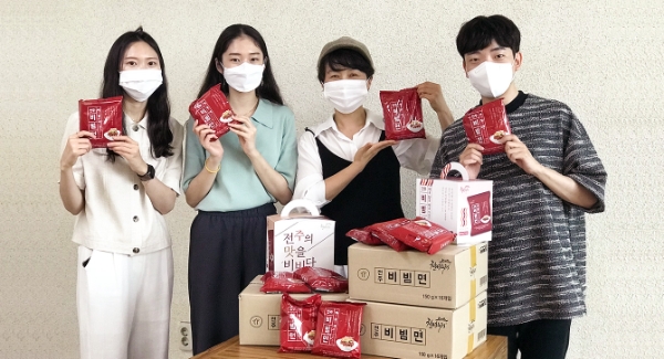 사회적기업 ㈜천년누리 장윤영 대표(왼쪽에서 세 번째)와 직원들이 대표 상품인 전주비빔면을 들어보이고 있다.