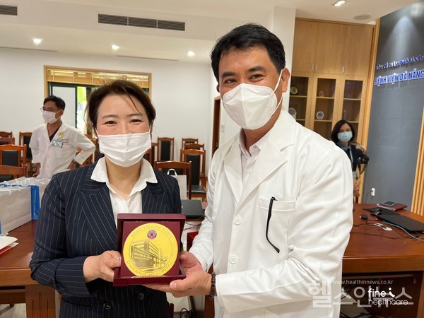 베트남다낭병원기념품을전달받으며(왼쪽)㈜파인헬스케어신현경대표와(오른쪽)베트남다낭병원LeDucNhan병원장이함께촬영한모습