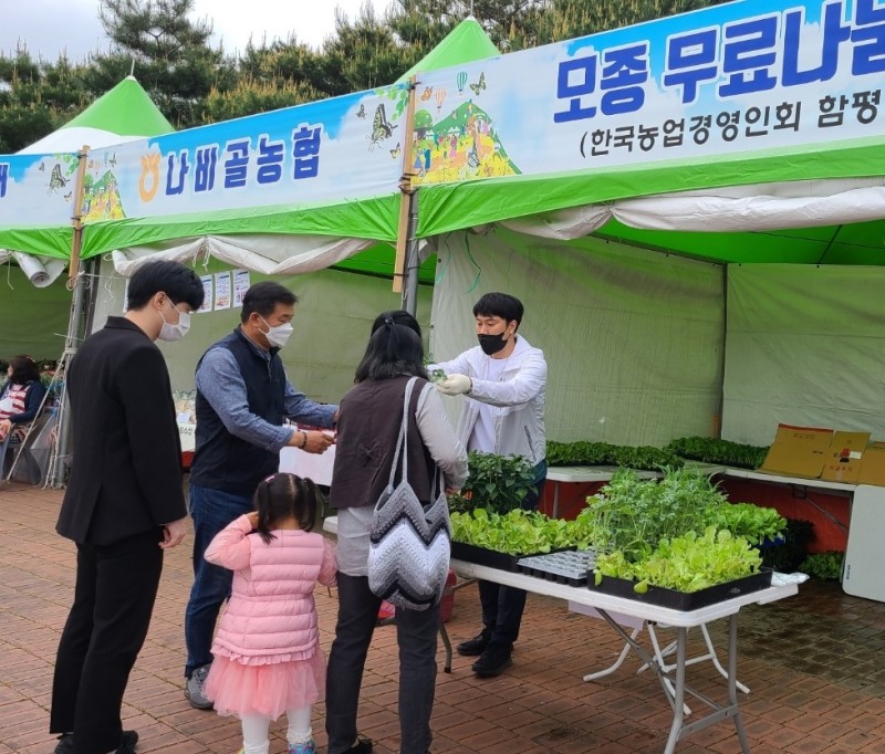 함평엑스포공원에서 축제를 찾은 군민과 관광객들에게 모종을 배부하는 모습 (사진제공 = 함평군)