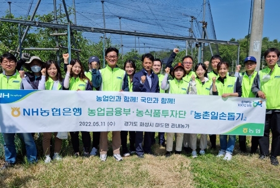 NH농협은행 농업금융부 서준호 부장(앞줄 왼쪽 네 번째)과 직원들이 경기도 화성시 마도면 소재 사과농장에서 일손 돕기 실시 후 기념촬영을 했다
