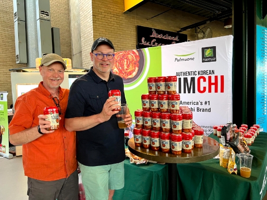 미국 마이너리그 야구팀 몽고메리 비스킷츠 홈구장에서 열린 풀무원 김치 증정 행사에 참여한 현지 관람객들이 제품을 들고 기념촬영을 하고 있다.