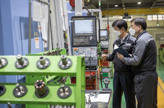 경기도 안산시에 위치한 금형생산기업 건우정공에서 박순황 회장(왼쪽)과 삼성전자 스마트공장지원센터 임선우 프로(오른쪽)가 CNC 가공설비를 살펴보고 있다