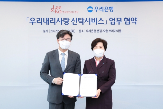 우리은행이 지난 24일 서울 중구 우리은행 본점에서 법무법인 광장과 ‘우리내리사랑 신탁서비스’ 업무협약을 체결했다. 송현주 우리은행 투자상품전략그룹장(오른쪽)과 법무법인(유) 광장 김상곤 대표변호사가 기념촬영을 하고 있다./사진 제공 = 우리은행