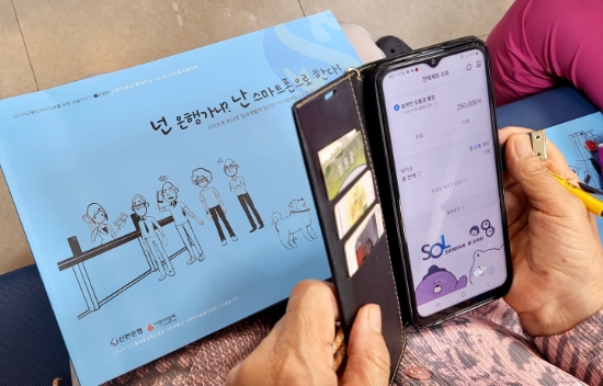 시니어 고객이 신한은행 하계동지점에서 신한 쏠( SOL) 교육용 어플리케이션을 이용해 체험하고 있는 모습