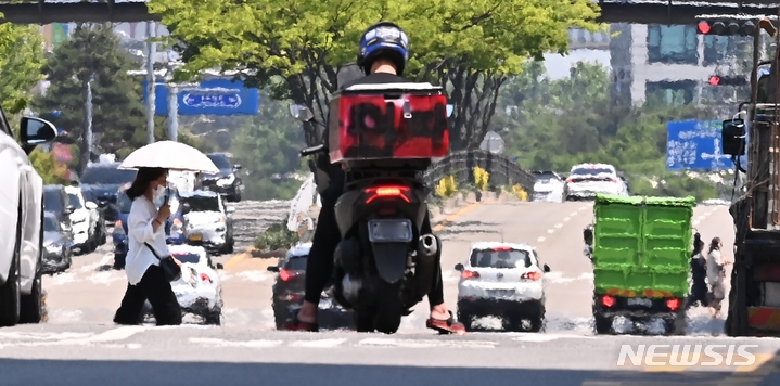 낮 최고기온이 30도 까지 오르는 등 전국이 여름 날씨를 보인 지난 24일 오후 경기도 수원시 인계동 도로에 지열로 인한 아지랑이가 피어오르고 있다.