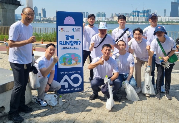 지난 11일 이촌 한강공원부터 망원 한강공원 일대에서 진행한 ‘함께 RUN 할래?’ 플로깅 DAY에서 신한은행 진옥동 은행장(가운데)과 오피니언 리더들이 함께 사진 촬영하고 있는 모습