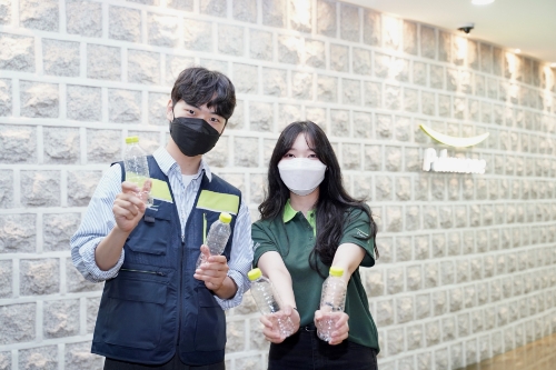 풀무원식품 가맹점 근무자들이 버려진 페트병을 재활용한 친환경 유니폼을 소개하고 있다. 유니폼은 폐페트병을 재활용한 폴리에스터 소재 재생 원단으로 만들어졌다.