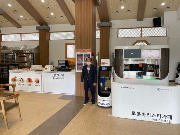신경주빵 성정표대표가 스토랑(주)의 로봇과 함께 오픈 기념 촬영을 하고 있다.