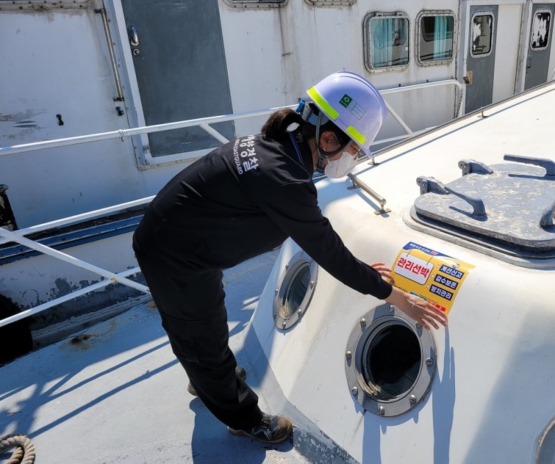 목포해경이 장기계류선박 대상으로 제작 스티커를 부착하고 있다. (사진제공 = 목포해양경찰서)