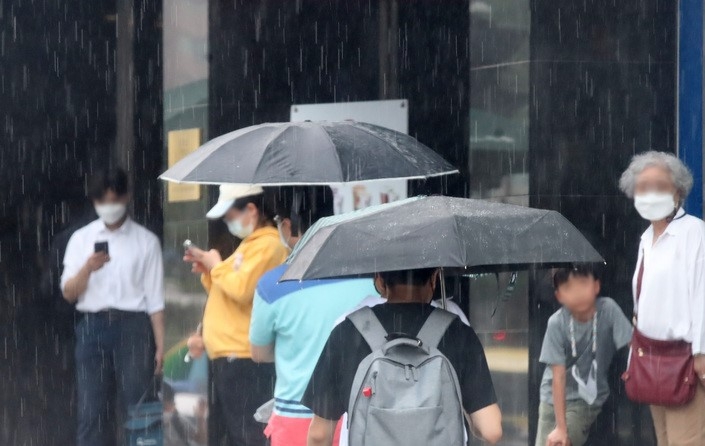 소나기가 쏟아진 지난 4일 오후 서울 중구 한 거리에서 시민들이 우산을 쓰고 걸어가고 있다.