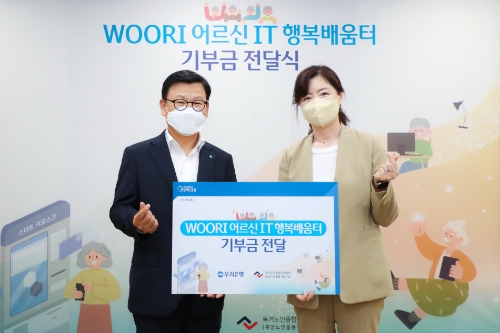 우리은행(은행장 이원덕)은 지난 13일 서울 중구 소재 우리은행 본점에서 'WOORI 어르신 IT 행복배움터' 기부금 전달식을 가졌다. 이원덕 우리은행장(왼쪽)과 김현미 독거노인종합지원센터 센터장이 기념촬영을 하고 있다./ 사진 제공 = 우리은행
