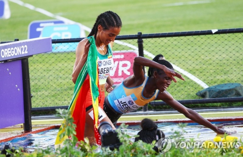 (유진 로이터=연합뉴스) 케냐에서 카자흐스탄으로 귀화한 제루토(오른쪽)가 21일(한국시간) 미국 오리건주 유진 헤이워드 필드에서 열린 2022 세계육상선수권 여자 3,000m 장애물 결선에서 우승한 뒤, '입수 세리머니'를 펼치고 있다.