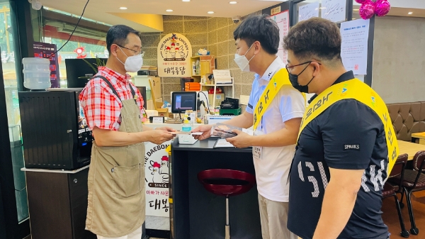 수원시주야간보호연합회가 수원 남문 통닭거리에서 노인학대예방 캠페인을 진행하고 있는 모습.