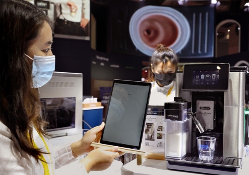 지난해 11월 5일 한 직원이 이탈리아의 커피머신 제조 기업인 드롱기(De'Longhi)의 전시 부스에서 앱(App)과 연동돼 원두 특성에 따라 커피 추출 방법을 자동으로 조정되는 스마트 커피머신을 보여주고 있다. / 사진 제공 = 신화통신