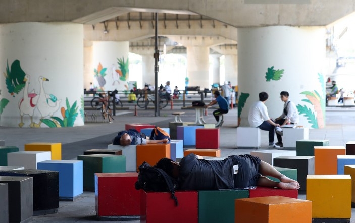 무더위가 기승을 부린 25일 오후 서울 영등포구 여의도한강공원을 찾은 시민들이 휴식을 취하고 있다.