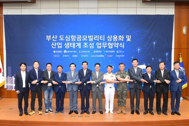 27일 오후 부산광역시청 국제회의장에서 열린 UAM 상용화 업무협약식에서 (왼쪽부터) 파블로항공 정덕우 운영이사 / LG유플러스 이상엽 전무 / 유승일 카카오모빌리티 부사장 / GS칼텍스 장인영 사장 / 제주항공 김이배 대표이사 / 박형준 부산광역시장 / 박일평 LG사이언스파크 대표 / 해군작전사령부 강동훈 사령관 / 육군53사단장 여인형 사단장 / GS건설 허윤홍 사장 / 한국해양대 도덕희 총장 / 부산시설공단 이해성 이사장 / 부산테크노파크 김형균 원장이 기념촬영을 하고 있는 모습.