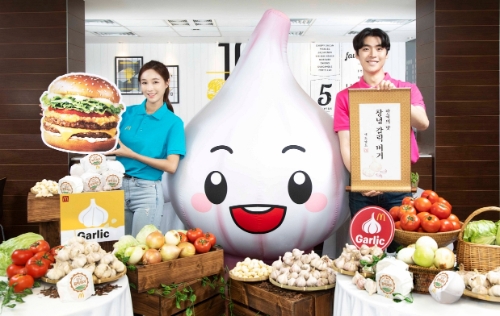 모델들이 고객 성원에 보답하고자 재출시된 맥도날드 '창녕 갈릭 버거’를 들고 포즈를 취하고 있다. / 사진 제공 = 맥도날드
