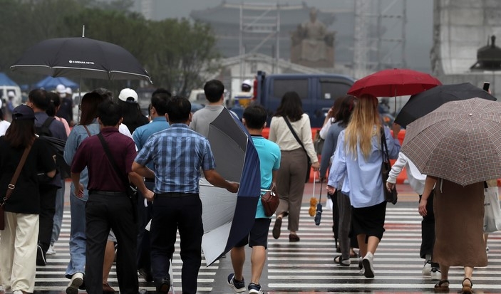 비가 내리다 그치기를 반복한 지난 3일 오전 서울 중구 세종대로사거리에서 시민들이 우산을 쓰거나 접고 이동하고 있다.