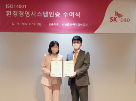 SK디앤디 ISO 14001 인증서 수여식에서 한국경영인증원 황은주 대표이사(좌)와 SK디앤디 지속가능경영위원회 황선표 위원(우)이 기념사진을 촬영하고 있다. (SK디앤디 제공)