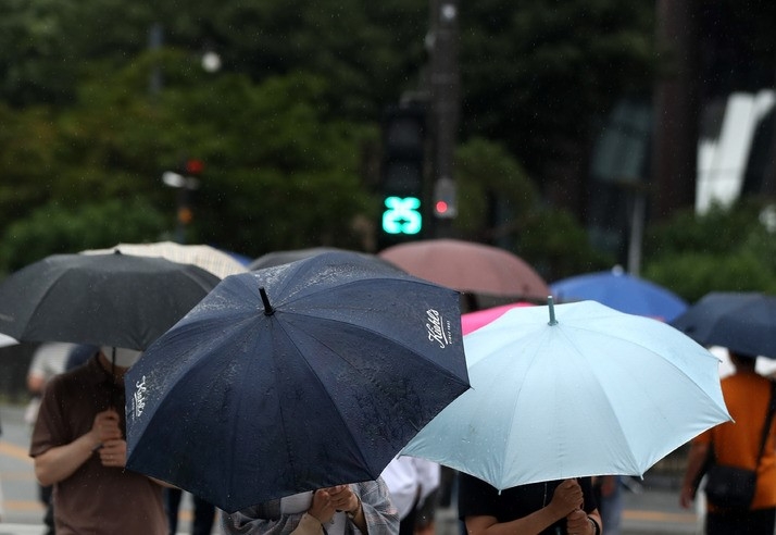 소강상태를 보이던 장맛비가 내린 지난 6월29일 오후 서울 중구 세종대로 사거리에서 우산을 쓴 시민이 발걸음을 재촉하고 있다.