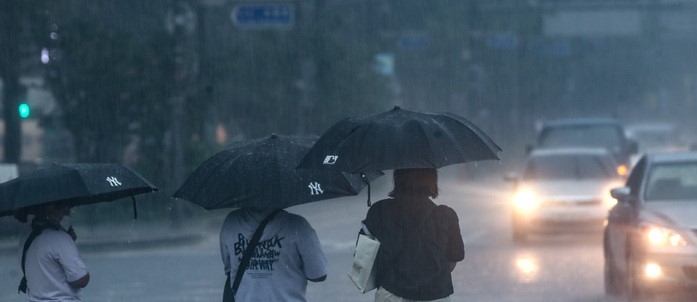지난 19일 오후 서울 중구 세종대로에서 시민들이 우산을 들고 있다.