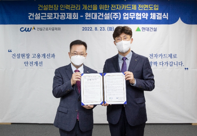 건설근로자 편의와 현장 인력관리 개선을 위한 건설근로자 전자카드제 전면도입을 위해 업무협약(MOU)을 현대건설과 건설근로공제회(공제회)가 23일 체결했다. 사진은 현대건설 추영기 안전사업지원실장과 공제회 송문현 전문이사가 서명식 이후 양사 주요 관계자들 앞에서 기념촬영을 하는 모습. (사진 = 현대건설 제공)