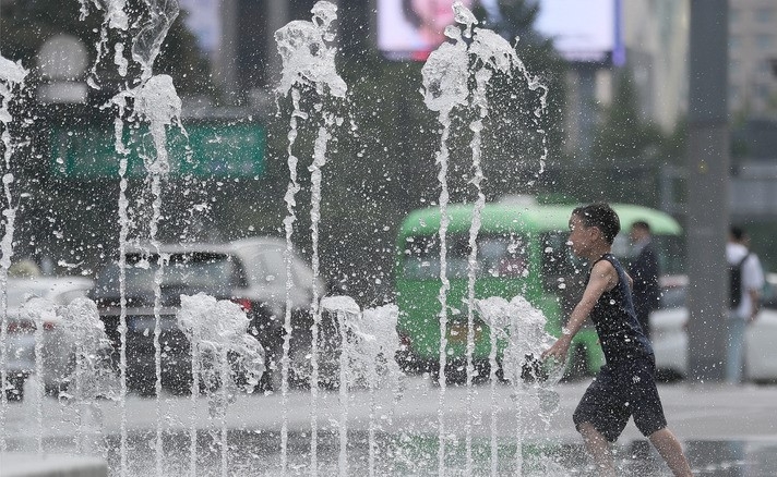 맑은 날씨를 보인 지난 26일 오후 서울 종로구 광화문광장 분수에서 한 어린이가 물놀이하고 있다.