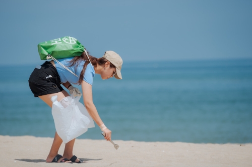참여자가 대여한 플로깅 도구로 해변에서 쓰레기를 줍고 있다.