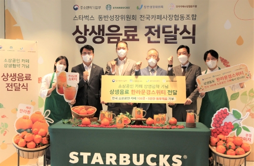 스타벅스 코리아가 8월 31일(수) 스타벅스 지원센터에서 우리 농산물을 활용해 동반성장위원회, 전국카페사장협동조합과 함께 개발한 상생음료인 ‘한라문경스위티’의 출시를 기념해 중소벤처기업부, 동반성장위원회, 전국카페사장협동조합과 함께 상생음료 전달식을 진행했다. 전달식에서 중소벤처기업부 조주현 차관(왼쪽 두번째), 스타벅스 송호섭 대표이사(왼쪽 세번째)와 동반성장위원회 오영교 위원장(왼쪽 네번째), 전국카페사장협동조합 고장수 이사장(왼쪽 다섯번째)이 기념 사진을 촬영하고 있다.