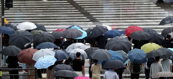 출근길에 비가 내린 지난달 30일 오전 서울 용산구 용산역 앞에서 우산을 쓴 시민들이 횡단보도 신호를 기다리고 있다.