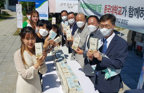 농협 상호금융예금자보호기금 박태선 위원장(농협중앙회 조합감사위원장, 오른쪽에서 두 번째)을 비롯한 관계자들이 2일 서울 중구 동국대학교 캠퍼스에서 '우리쌀 나눔 및 상호금융예금자보호제도 홍보'행사를 개최하고 학생들에게 진공포장 쌀을 전달하고 있다.