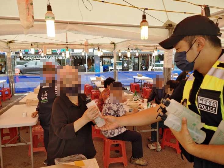 여수해양경찰이 녹동 바다불꽃축제 관광객 대상으로 손소독제를 배부하고 있다 (사진제공 = 여수해양경찰서)