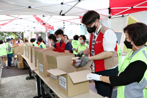 롯데홈쇼핑 임직원 '샤롯데봉사단'과 영등포구사회복지협의회 '좋은이웃들' 자원봉사자들이 차례상 꾸러미를 포장하고 있는 모습)