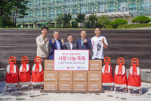 BC카드가 6일 오전 서울특별시 중구에 거주하는 취약계층 400가구를 대상으로 따듯한 한가위를 지원하기 위해 명절음식 등이 담긴 꾸러미를 전달했다. 사진은 중구청 앞마당에서 최원석 BC카드 대표이사 사장(왼쪽에서 2번째), 김길성 서울특별시 중구청장(왼쪽에서 3번째), 전명수 서울특별시사회복지협의회 사무총장(오른쪽에서 2번째), 조명식 BC카드 페이북본부장(맨 왼쪽), 김도영 그래픽 아티스트(맨 오른쪽)이 꾸러미 전달을 기념하는 모습.