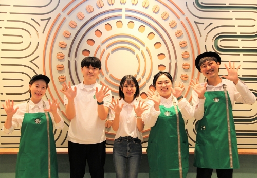 스타벅스 사진자료3_스타벅스 파트너와 청년인재들이 스타벅스 대학로점에 새롭게 선보인 81명의 청년인재를 상징하는 81개의 원두 아트월 앞에서 스타벅스 대학로점의 8주년을 기념하고 있다.