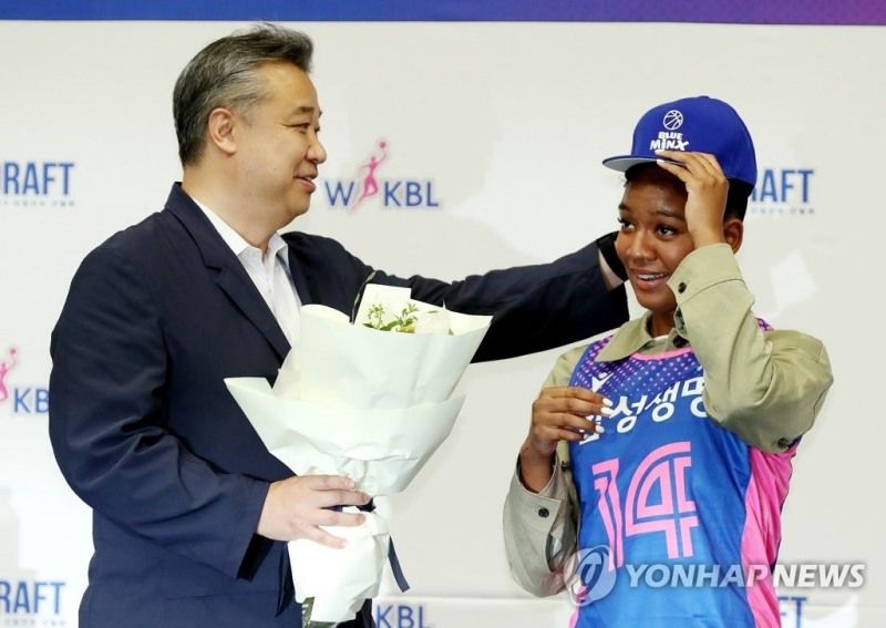 (인천=연합뉴스) 16일 오후 인천 도원체육관에서 열린 2022∼2023 WKBL(한국여자농구연맹) 신입선수 선발회에서 전체 1순위로 삼성생명에 지명된 키아나 스미스가(오른쪽) 임근배 삼성생명 감독의 도움을 받으며 모자를 쓰고 있다.