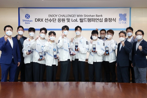 지난20일 서울시 중구 소재 신한은행 본점 회의실에서 진행된 ‘DRX 소속 e스포츠 선수단 응원 행사’에서 신한은행 진옥동 은행장(오른쪽 세번째)과 DRX 최상인 대표(왼쪽 두번째)를 비롯한 DRX 소속 e스포츠 선수들 및 두 회사 관계자들이 기념촬영하는 모습