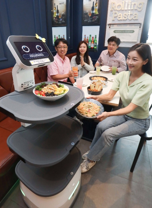 LG전자는 다양한 B2B 유·무선 통신 서비스 노하우를 쌓아온 LG유플러스와 협력해 서비스 로봇 시장을 공략한다. 양사는 더본코리아 매장 내 LG 클로이 로봇 시범 운영을 시작으로 다른 매장들로 로봇 공급 확대를 추진할 계획이다. 사진은 더본코리아의 롤링파스타 매장에서 LG 클로이 서브봇이 손님에게 음식을 서빙하는 모습. (사진 = LG전자 제공)