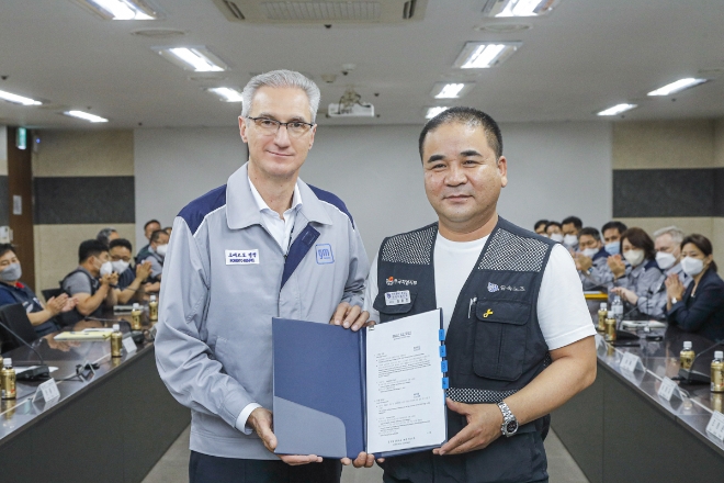 한국지엠 노사가 2022년 임단협 교섭 합의안에 대한 조인식을 갖고 기념 촬영을 하고 있다. (좌측부터) 로베르토 렘펠 한국지엠 사장, 금속노조 한국지엠지부 김준오 지부장. (사진 = 한국지엠 제공)