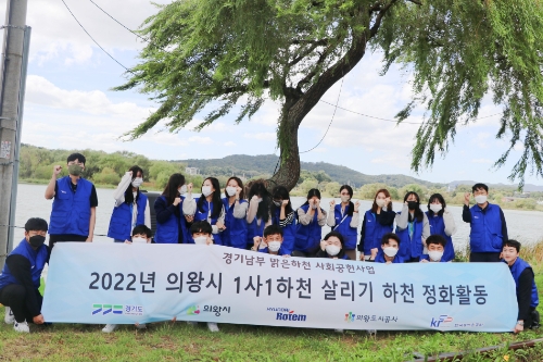 지난 23일 현대로템 임직원들이 경기도 의왕시 왕송호수 및 금천천 일대에서 환경정화활동 후 기념촬영을 하고 있다.