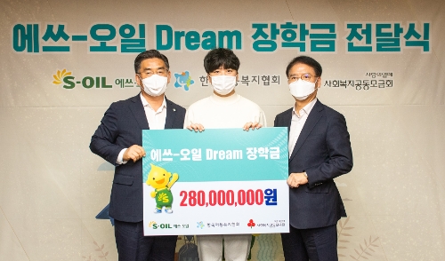 S-OIL 류열 사장(오른쪽)이 장학금을 전달하고, 한국아동복지협회 신정찬 회장(왼쪽)과 기념촬영을 하고 있다.